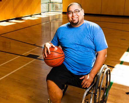 Man in wheelchair holding basketball