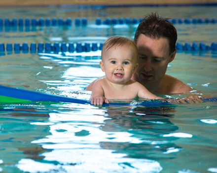 Baby and father in swimming pool